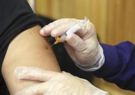FILE - In this Friday, Sept. 22, 2017 file photo, a flu vaccine injection is administered at the Brownsville Events Center by a pharmacist in Brownsville, Texas. According to data released by the Centers for Disease Control and Prevention on Friday, Dec. 8, 2017, this year's flu season is off to a quick start and so far it seems to be dominated by a nasty bug. (Miguel Roberts/The Brownsville Herald via AP)
