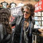Joe Perry signed an autograph for Kelsey Sullivan at Newbury Comics in Boston on Thursday. 