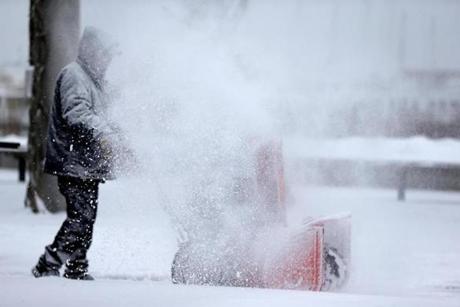 A man is obscured by snow as he cleared an area in Boston on Tuesday. 
