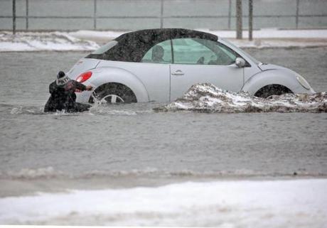 Beth Troupe tripped after she tried to move her car in a flooded parking lot in Scituate on Tuesday.
