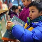 Michael Ruan, 5, looked at books at the new Boston Public Library temporary branch inside the China Trade Center.