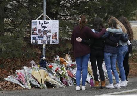 Students embraced as they pay their respects at a makeshift memorial for two Needham High School students, Talia Newfield and Adrienne Garrido who were struck and killed by a car. 
