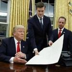 White House Staff Secretary Rob Porter handed President Donald Trump a confirmation order in January, 2017.