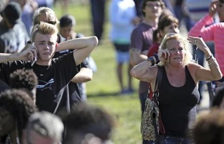 SCHOOL SHOOTING SLIDER Waiting for word from students anxious family members gather at Coral Springs Drive and the Sawgrass Expressway, just south of the campus ,following a shooting at Marjory Stoneman Douglas High School in Parkland, Fla., Wednesday, Feb. 14, 2018. (Amy Beth Bennett/South Florida Sun-Sentinel via AP)
