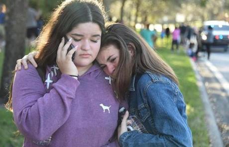 SCHOOL SHOOTING SLIDER TOPSHOT - Students react following a shooting at Marjory Stoneman Douglas High School in Parkland, Florida, a city about 50 miles (80 kilometers) north of Miami on February 14, 2018. A gunman opened fire at the Florida high school, an incident that officials said caused 