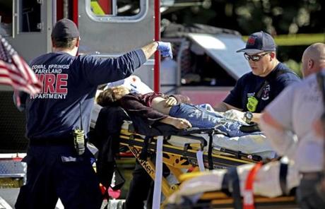 SCHOOL SHOOTING SLIDER Medical personnel tend to a victim following a shooting at Marjory Stoneman Douglas High School in Parkland, Fla., on Wednesday, Feb. 14, 2018. (John McCall/South Florida Sun-Sentinel via AP)
