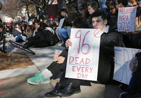 Students sat on the sidewalk after a walk-out at Somerville High School Wednesday.  

