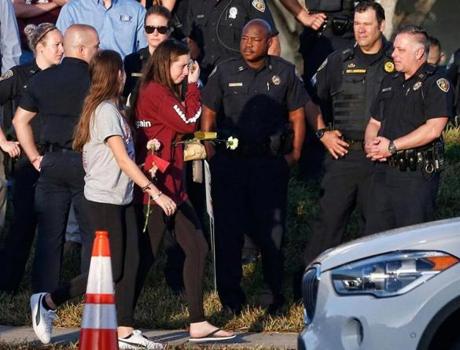 Marjory Stoneman Douglas High School staff, teachers and students return to school greeted by police and well wishers in Parkland, Florida on February 28, 2018. Students grieving for slain classmates prepared for an emotional return Wednesday to their Florida high school, where a mass shooting shocked the nation and led teen survivors to spur a growing movement to tighten America's gun laws. The community of Parkland, Florida, where residents were plunged into tragedy two weeks ago, steeled itself for the resumption of classes at Marjory Stoneman Douglas High School, where nearby flower-draped memorials and 17 white crosses pay tribute to the 14 students and three staff members who were murdered by a former student. / AFP PHOTO / RHONA WISERHONA WISE/AFP/Getty Images
