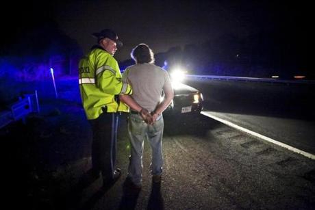 Trooper Matthew Sheehan (left) took a suspected drunk driver into custody along I-93 in 2011. 
