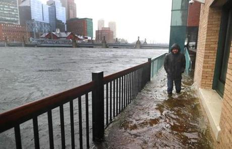 STORM SLIDER Boston-03/02/18-A man walks slowly through a flooded sidewalk off Congress Street, where water was flowing over from Fort Point Channel in the Seaport district. John Tlumacki/Globe Staff(metro)
