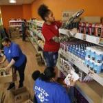 From left to right,  Dianne Harley broke down boxes as Nichole Campbell and Tajanae Ivey-Nares worked to stock the shelves before the grand opening of The Daily Table.