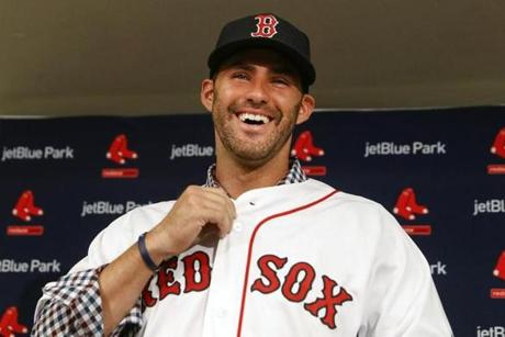 Boston Red Sox baseball player J.D. Martinez smiles as he buttons up his jersey during an introductory news conference, Monday, Feb. 26, 2018, in Fort Myers, Fla. (AP Photo/John Minchillo)
