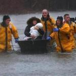 Quincy-03/02/18-A mother and child are rescued by a boat from their home. Many water rescue evacuations took place at residences flooded onPost Island Road in the Houghs Neck section of Quincy. Quincy firefighters used boats and front end loaders to rescue many residents. John Tlumacki/Globe Staff(metro)