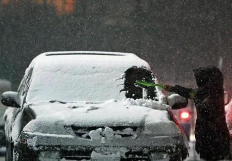 Fitchburg, MA: 3/7/2018: A motorist cleans snow off of their car in the parking lot of the Central Plaza near downtown Fitchburg as the storm intensifies. Another winter storm is predicted to hit the area this afternoon and tonight. (Jim Davis/Globe Staff)
