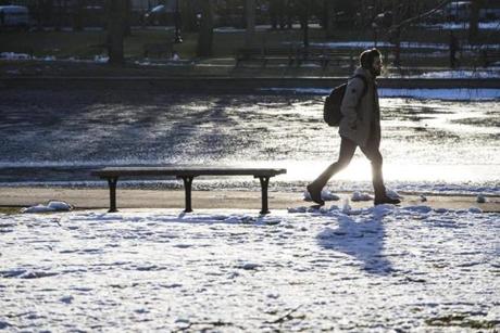 A man walked near frozen snow on the ground in the Public Garden in Boston on Monday. 
