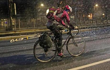 A bicyclist toting skis rode down Commonwealth Avenue in Boston early Tuesday morning.
