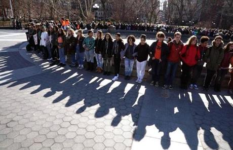 WALKOUT SLIDER Students from Harvest Collegiate High School form a circle around the fountain in Washington Square Park on March 14, 2018 in New York to take part in a national walkout to protest gun violence, one month after the shooting in Parkland, Florida, in which 17 people were killed. Students across the US walked out of classes on March 14, in a nationwide call for action against gun violence following the shooting deaths last month at a Florida high school. The nationwide protest is being held one month to the day after Nikolas Cruz, a troubled 19-year-old former student at Stoneman Douglas, unleashed a hail of gunfire on his former classmates. / AFP PHOTO / TIMOTHY A. CLARYTIMOTHY A. CLARY/AFP/Getty Images
