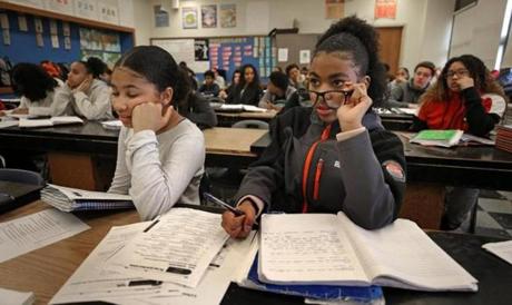 Student Dailene Barros uses borowed eye glasses from fellow classmate Joceline Alexandra Oliveira (left) in grade 8 science class at North Middle School in Brockton. 
