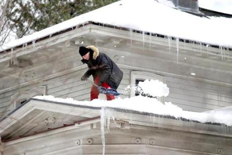A man cleared snow off his roof in Sudbury last week.
