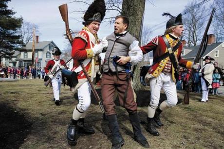 Reenactors playing the part of His Majesty?s 10th Regiment Of Foot Rob Lee, left, and his son Matt Lee, right, arrested Jim Griffiths of the Bedford Minuteman Company after he capped the pole in Willson Park on Saturday.
