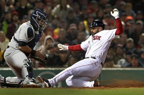 Boston, MA: 4/12/18: The Red Sox Sandy Leon slides safewly into home plate as he scores on a bottom of the second inning infield ground ball hiy by Andrew Benintendi. he Yankees catcher is Gary Snachez. The Boston Red Sox hosted the New York Yankees in a regular season MLB baseball game at Fenway Park. (Jim Davis/Globe Staff)
