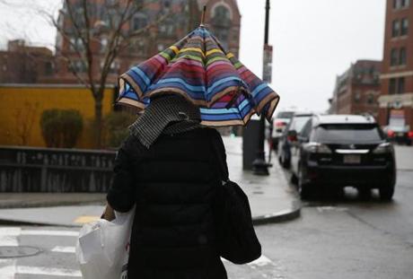 Boston, MA -- 3/07/2018 - A woman walks under an umbrella as rain falls in Boston. (Jessica Rinaldi/Globe Staff) Topic: 08weather Reporter: 
