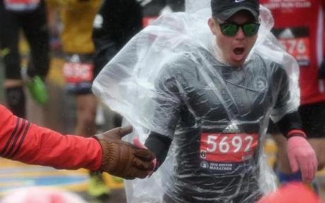 MARATHON SLIDER HOPKINTON, MA - 4/16/2018: Boston Marathon Start.....gloves needed for cold hands as a volunteer slaps hands with a runner (David L Ryan/Globe Staff ) SECTION: SPORTS TOPIC Boston Marathon
