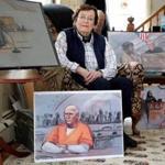 Jane Collins in her Duxbury home with some of her best-known courtroom drawings.