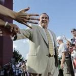 Former New England Patriots broadcaster Gil Santos is congratulated by fans as he walks the red carpet in Foxborough, Mass., Monday, July 29, 2013. Santos and former linebacker Tedy Bruschi were inducted into the Patriots 2013 Hall of Fame. (AP Photo/Charles Krupa)