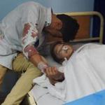 A man comforted a wounded child who was being treated at a hospital Sunday after a suicide bombing attack in Kabul. 