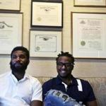 In this Wednesday April 18, 2018 photo, Rashon Nelson, left, and Donte Robinson, right, sit on their attorney's sofa as they pose for a portrait following an interview with The Associated Press in Philadelphia. Their arrests at a local Starbucks quickly became a viral video and galvanized people around the country who saw the incident as modern-day racism. In the week since, Nelson and Robinson have met with Starbucks CEO Kevin Johnson and are pushing for lasting changes to ensure that what happened to them doesn't happen to future patrons. (AP Photo/Jacqueline Larma)