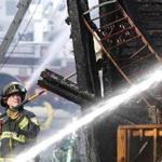 A firefighter battled a massive fire at three triple-decker apartment buildings on John Street in Chelsea.