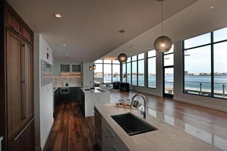 Pier 4 model home interiors with two different styled kitchens and view of Boston Harbor. 
