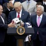 President Donald Trump was presented a New England Patriots helmet by head coach Bill Belichick, left, and owner Robert Kraft, right, during a 2017 ceremony that followed the Patriots? Super Bowl victory. 