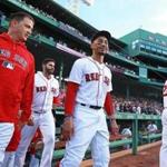 Boston, MA: 5-14-18 Newly activated Red Sox pitcher Steven Wright (far left) comes out of the dugout for the national anthem with teammates J.D. Martinez and Mookie Betts, The Boston hosted the Oakland Athletics in a regular season MLB baseball game at Fenway Park. (Jim Davis/Globe Staff)