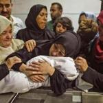 A mother held her 8-months baby, Leila al-Ghandour, at the morgue of al-Shifa hospital in Gaza Cityon Tuesday. 
