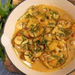Monkfish tail medallions are seared in a pan and served with mushrooms in Marsala wine sauce.