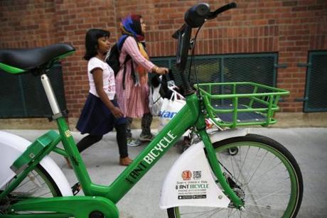 Cambridge, MA--5/14/2018-- People walk past an Ant Bicycle parked outside of the Garment District on Broadway is seen in Kendall Square. dockless bike share (Jessica Rinaldi/Globe Staff) Topic: 12bikeshare Reporter:
