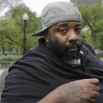 In this Wednesday, May 16, 2018 photo Emory Ellis, of Boston, sits for a photo in a park, in Boston. Ellis was arrested in 2015 after he tried to buy breakfast at Burger King using a $10 bill that the cashier thought was fake. Ellis? arrest resulted in a probation violation that landed him in jail for three months before prosecutors dropped the charge when authorities determined the bill was real. Ellis is suing Burger King accusing them in a lawsuit filed this week of discriminating against him because he?s black and homeless. (AP Photo/Steven Senne)