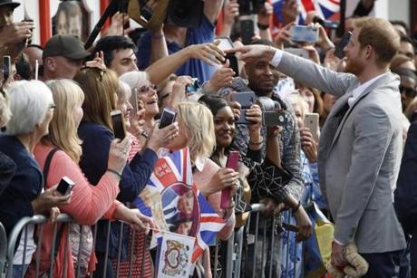Britain?s Prince Harry greets well-wishers on the street outside Windsor Castle on Friday.

