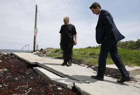Nahant selectman Enzo Barile (left) and state Senator Brendan Crighton toured the coastline last week. They looked at a sidewalk near Short Beach that was damaged by winter storms.

