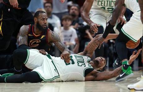 Cleveland, OH: 5-25-18: The Celtics Marcus Smart gets rid of the ball from the floor as the Cavaliers LeBron James defends during a fourth quarter loose ball scrum. The Boston Celtics visited the Cleveland Cavaliers for Game Six of their NBA Eastern Conference Finals playoff series at the Quicken Loans Arena. (Jim Davis/Globe Staff)
