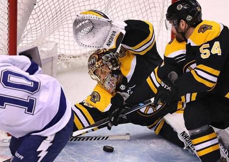 Boston Bruins goalie Tuukka Rask makes a save on a close shot by J.T. Miller of the Tampa Bay Lightning as Bruin Adam McQuaid closes in. 
