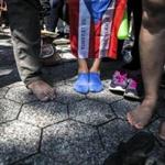 Protesters on Saturday took off their shoes as a symbol of the people who died as a result of the storm but who were not immediately counted.
