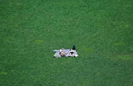 A couple found a green spot to relax and enjoy the sun in Boston?s Seaport District.:
