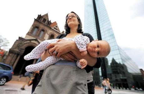 While holding her 7-week-old daughter Leah, Rebecca Zanconato of Sutton listens to the first speaker at the Rally to Improve Birth, held in Copley Square to address the ?broken maternity-care system.
