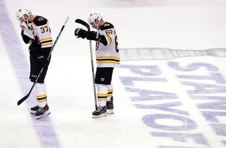 Their season over, Boston Bruins center Patrice Bergeron (37) and left wing Brad Marchand (63) stand dejectedly as they prepare to shake hands with Tampa players at Amalie Arena in Tampa.
