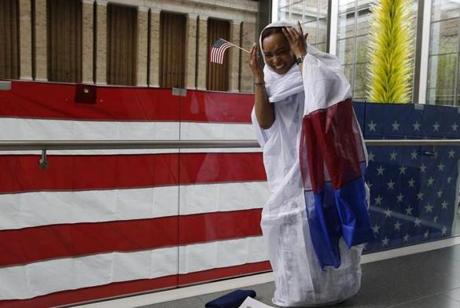 Lemina Cisse, who is from Mauritania, laughs as she fixed her head covering while posing for a picture upon becoming a US citizen. The naturalization ceremony was held at the Museum of Fine Arts.
