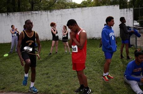 Jair Ayalas of South Boston High School takes a moment to pray before participating in the boy?s mile at the Boston City League Track and Field Championship at White Stadium.
