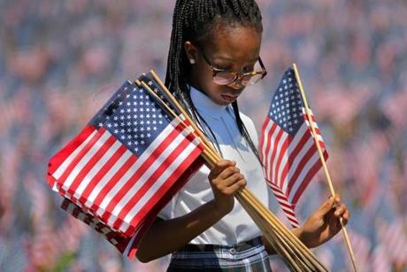 Timandi McFall, 11, of the St. John Paul II Catholic Academy, was among hundreds of volunteers who placed flags on Boston Common for Memorial Day.
